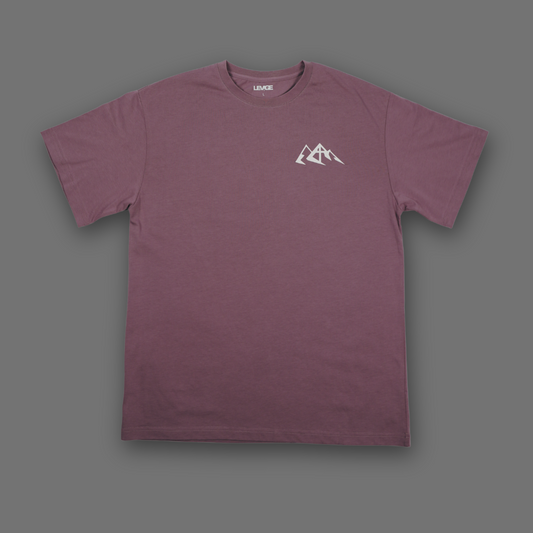 An English lavender short-sleeve crewneck t-shirt with a small white mountain graphic on the left chest, displayed flat against a solid dark gray background.