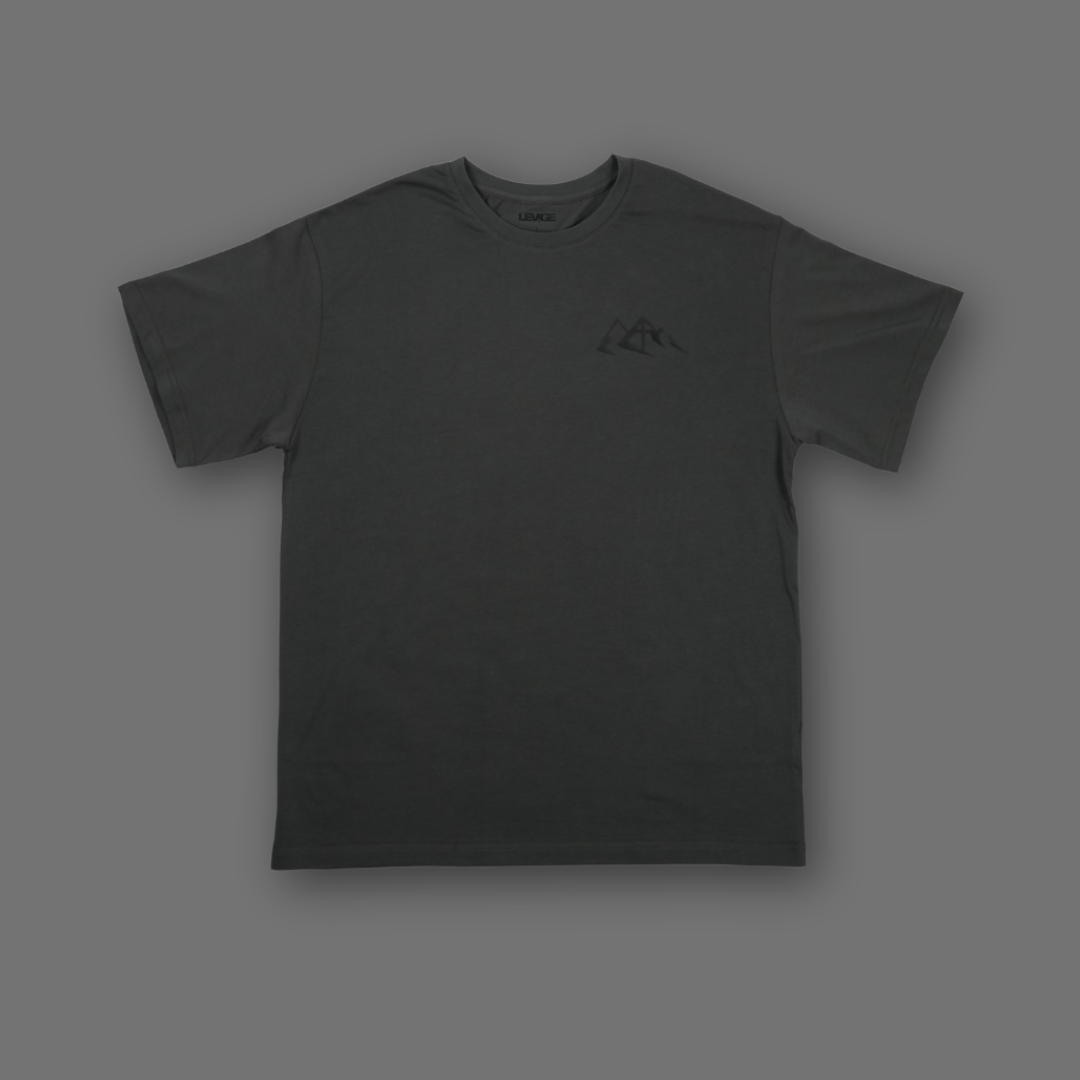A dark gray short-sleeve crewneck t-shirt with a small black mountain logo on the left chest, displayed against a solid dark gray background.