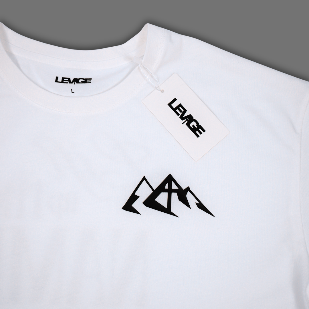 White short-sleeve crewneck t-shirt with a black mountain logo on the chest and a visible LEVAGE brand hangtag.